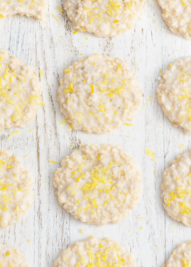 A stack of golden brown lemon oatmeal cookies with a delicate lemon glaze drizzle.