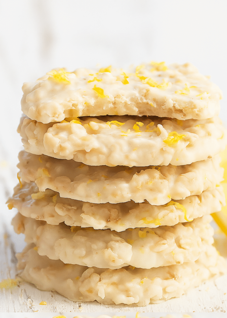 A stack of golden brown lemon oatmeal cookies with a delicate lemon glaze drizzle.